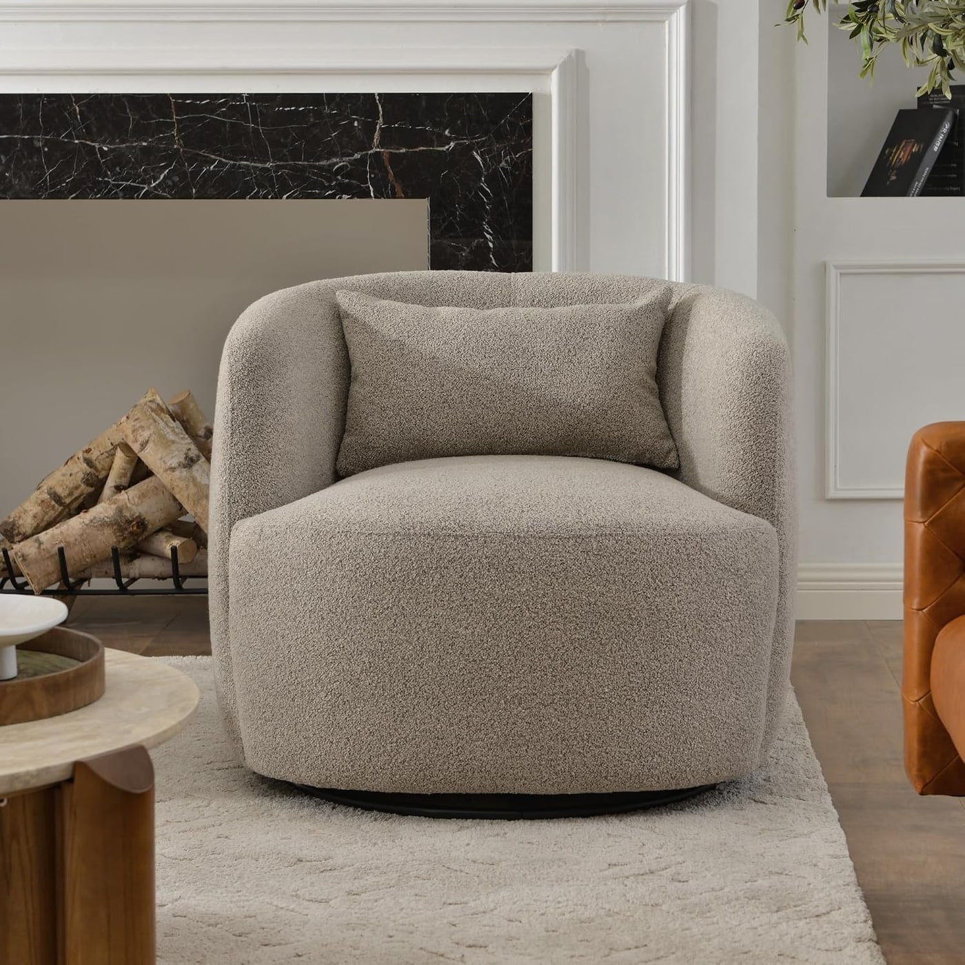 A large, plush boucle barrel swivel chair with lumbar pillow in a neutral color, shown from an angle