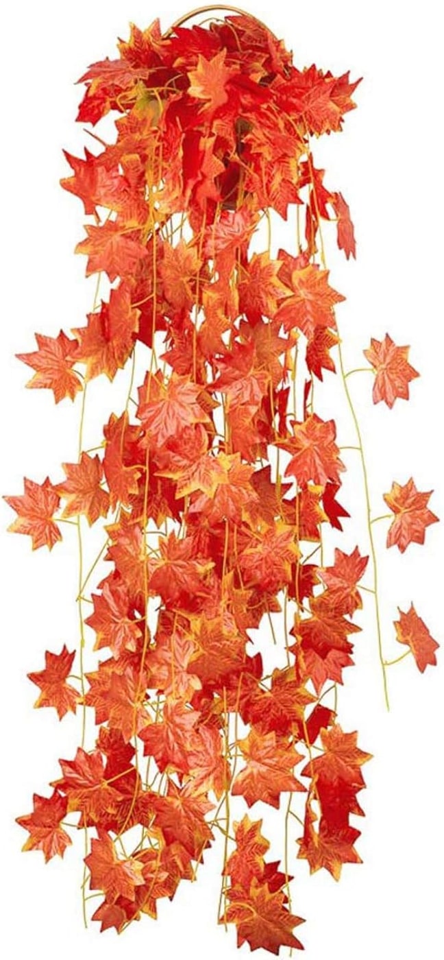Long artificial maple leaf garland in warm fall colors, artfully draped across a table