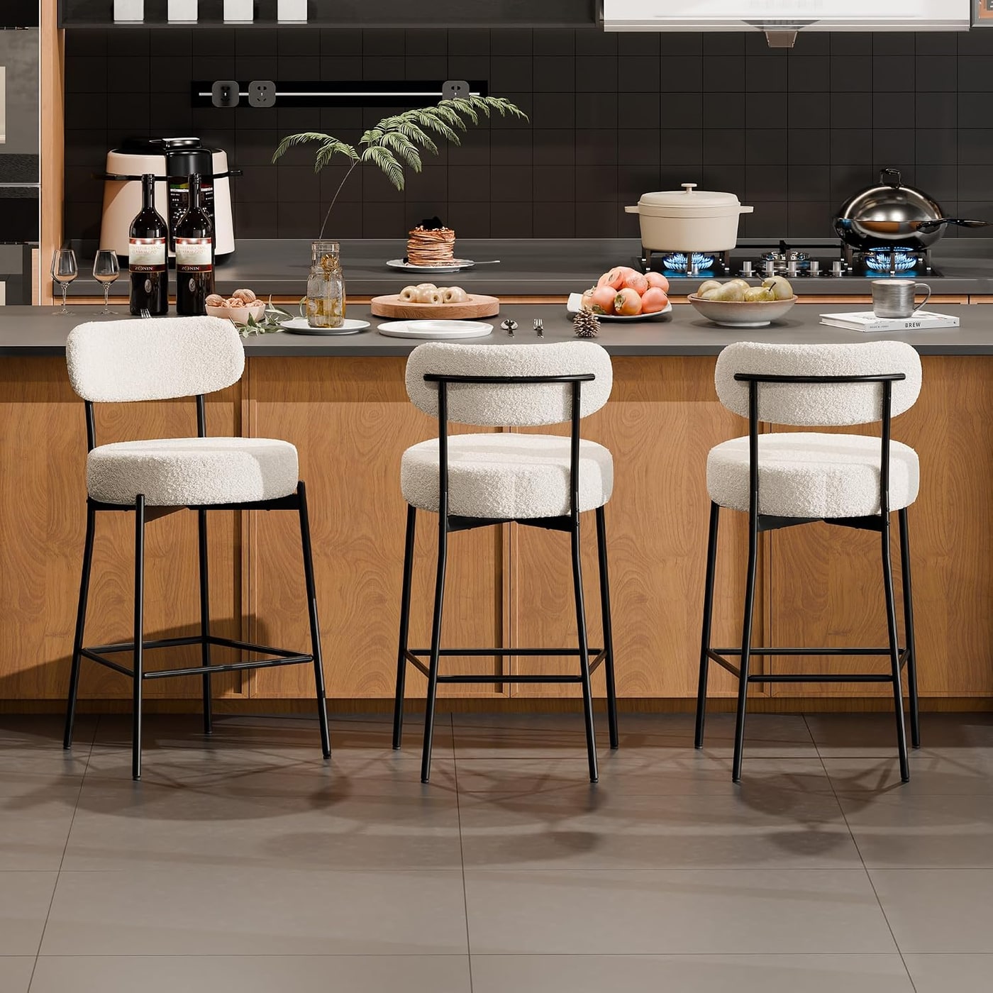 Set of three white boucle counter stools with curved backrests and metal frames arranged beside a kitchen island