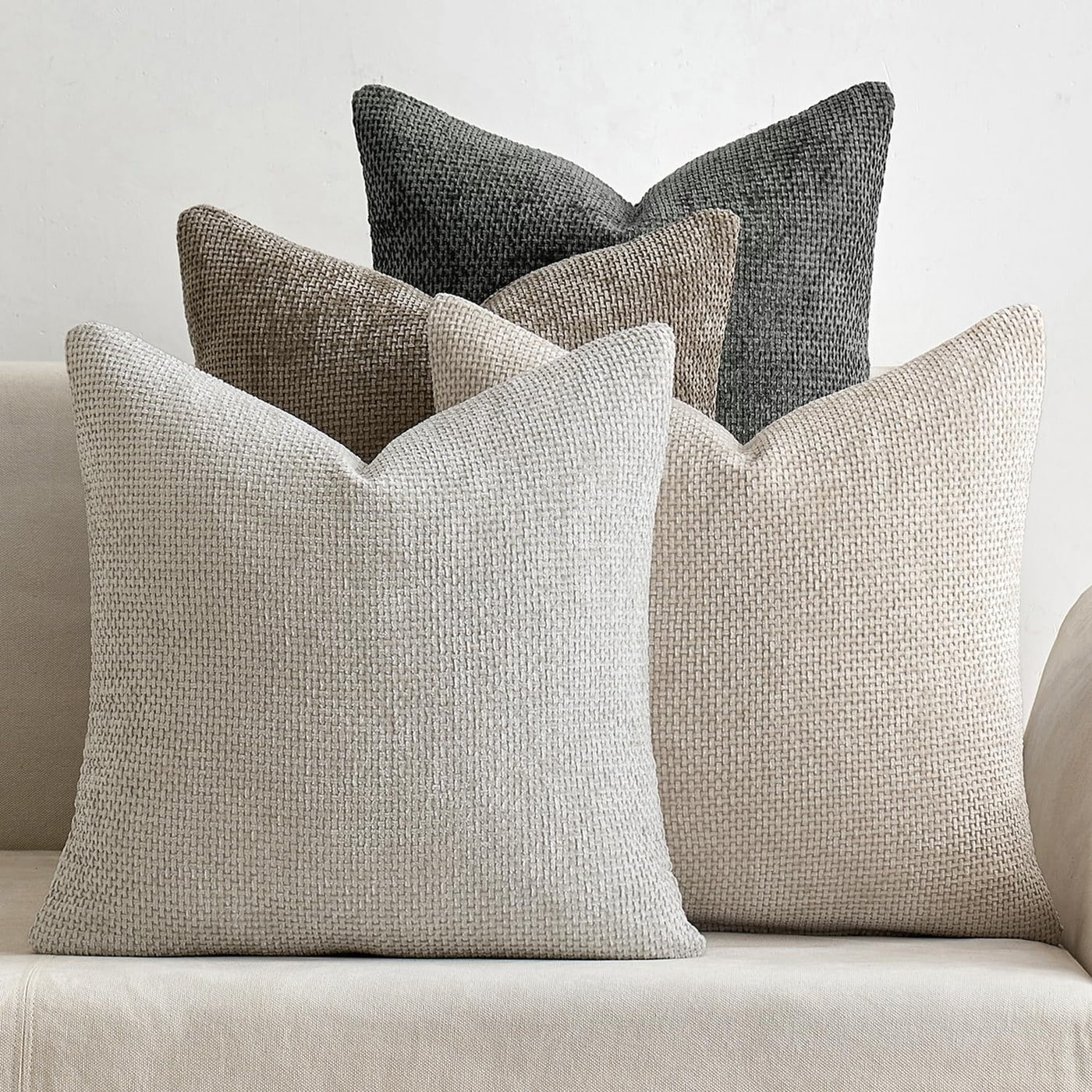Set of four plush chenille throw pillow covers in taupe, gray, and brown tones, stacked and arranged to show the soft texture.