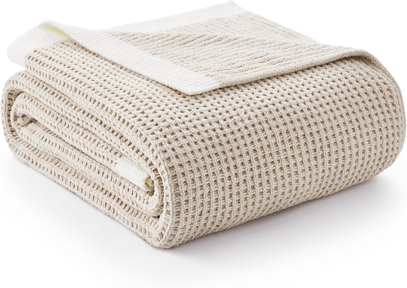 Amélie Home beige waffle knit chenille throw blanket draped over a sofa arm with visible waffle and striped textures