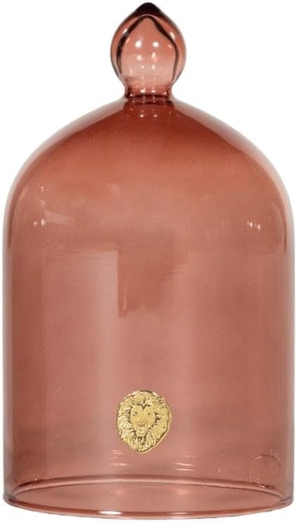 Glass cloche dome with spice-tinted glass and gold lion emblem on a neutral tabletop
