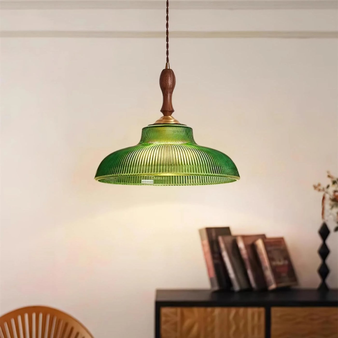 Green ribbed glass pendant light with wooden finial and brass hardware, suspended against a neutral background