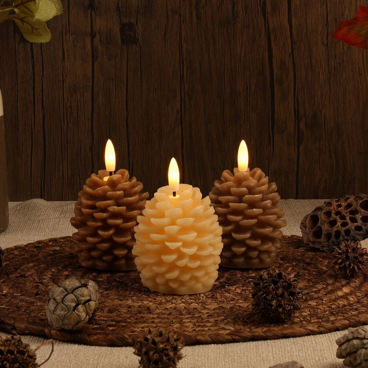 Three brown flameless LED pinecone candles with realistic wax texture in a simple fall arrangement