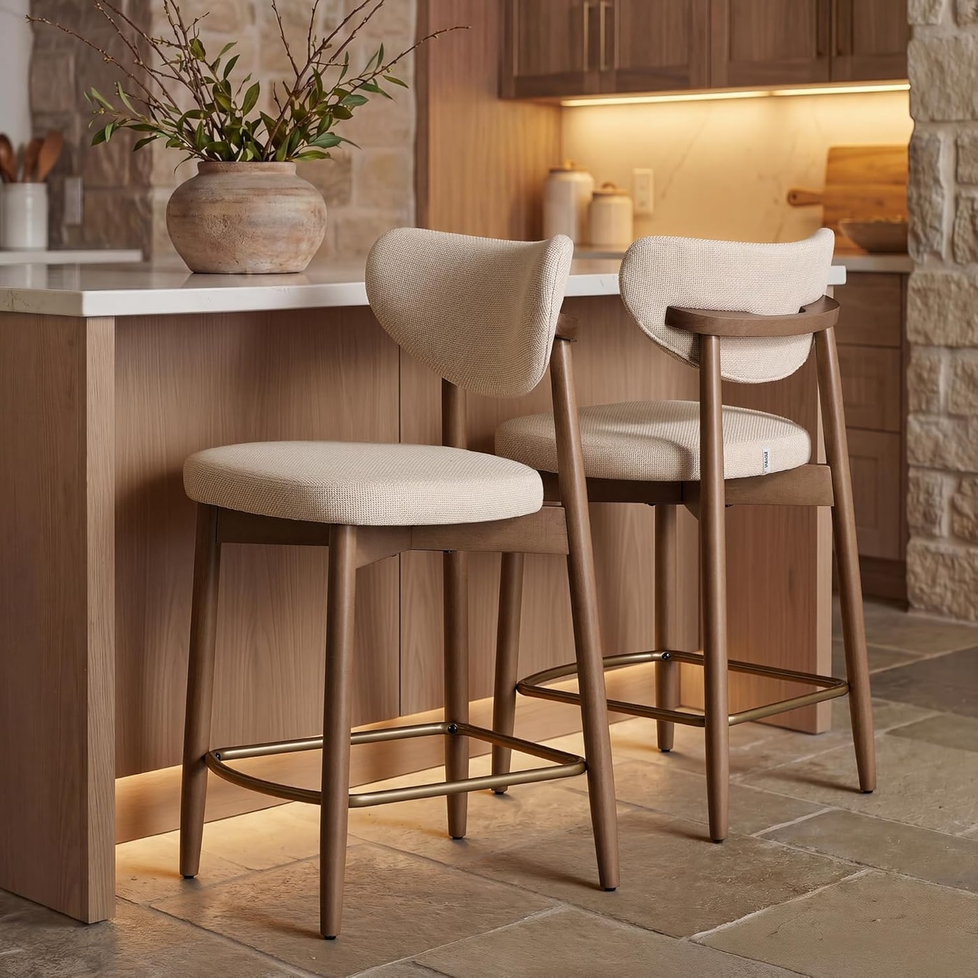 Pair of Mazio linen-look bar stools with curved backrests and tapered wood legs in a light-filled dining space