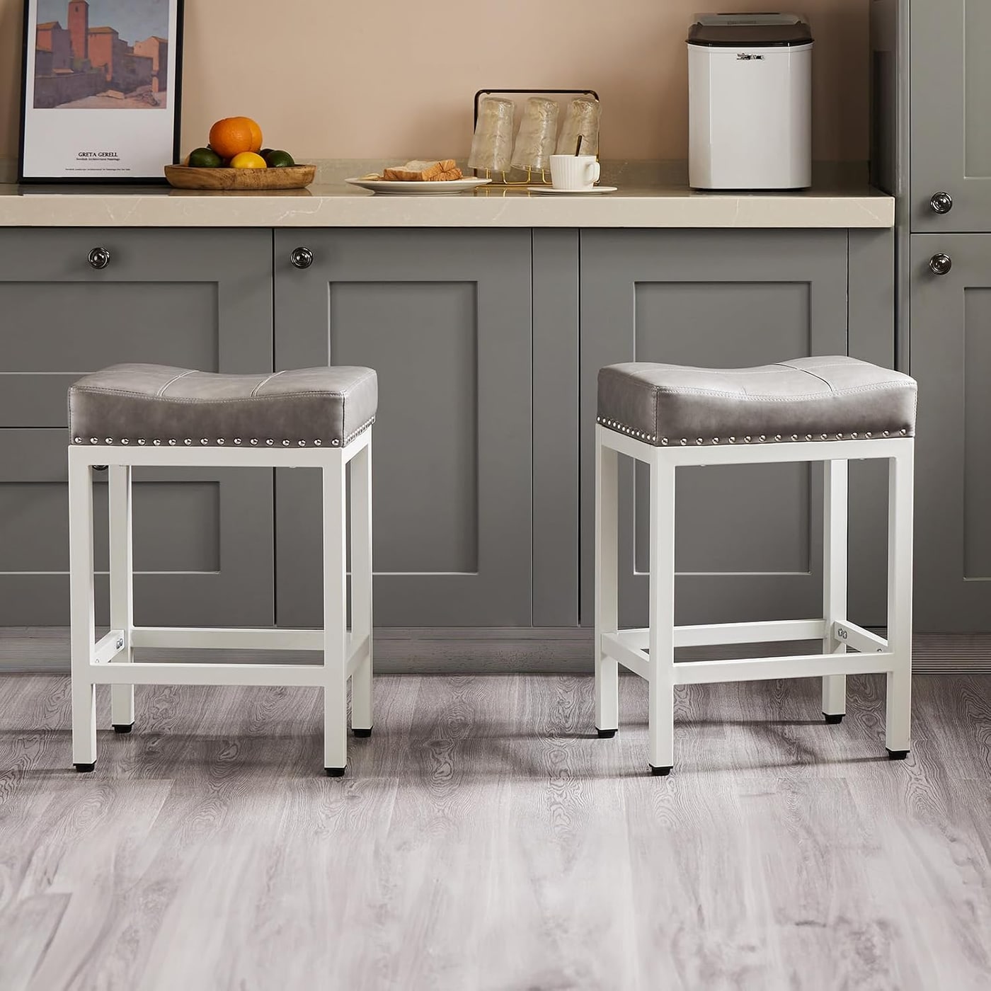 Pair of modern grey saddle-style bar stools with slim metal legs and PU leather seats