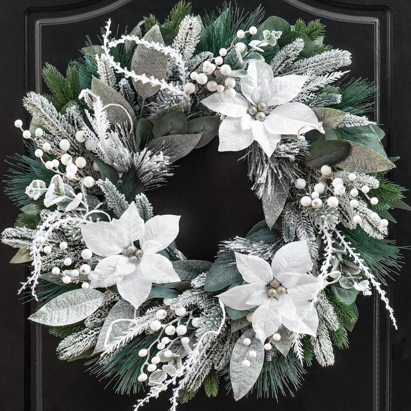 Full snowy eucalyptus Christmas wreath with white flowers and berries against a white background