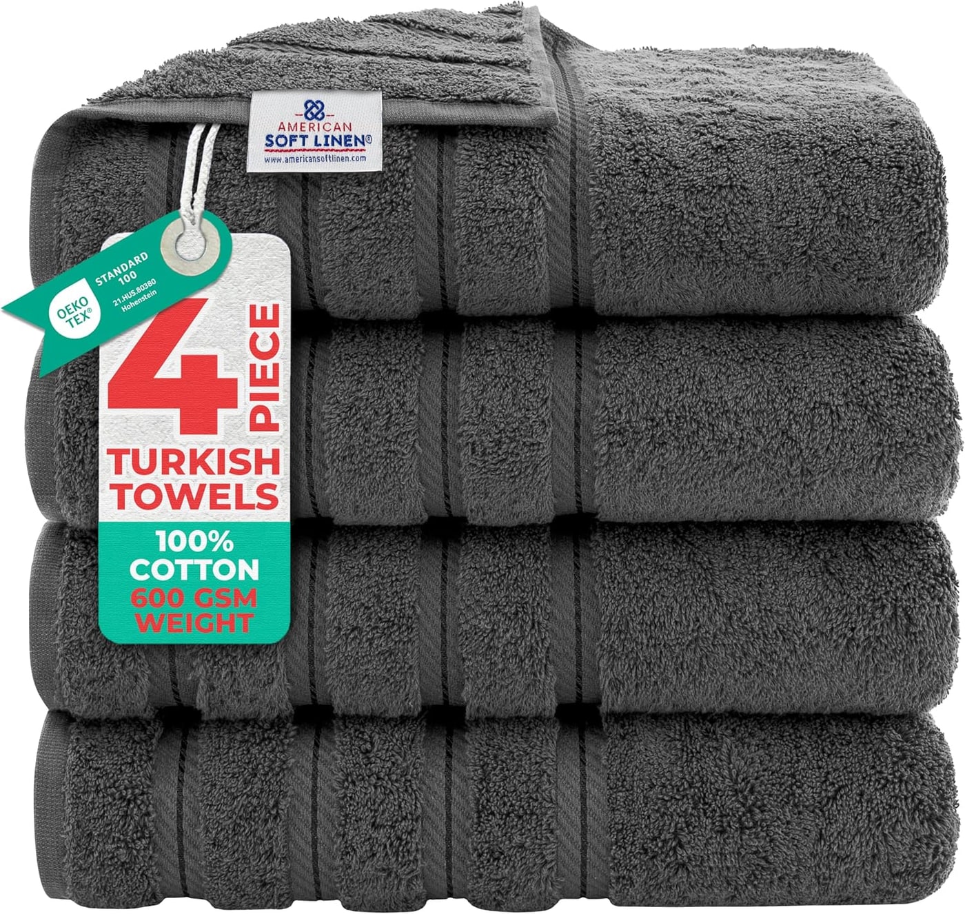 Four plush Turkish cotton bath towels in dark gray, neatly folded to show their oversized dimensions and soft weave.