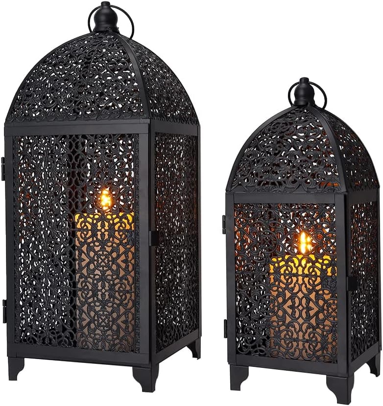Set of two vintage black metal lanterns with intricate cutout patterns, shown on a tabletop with handles upright