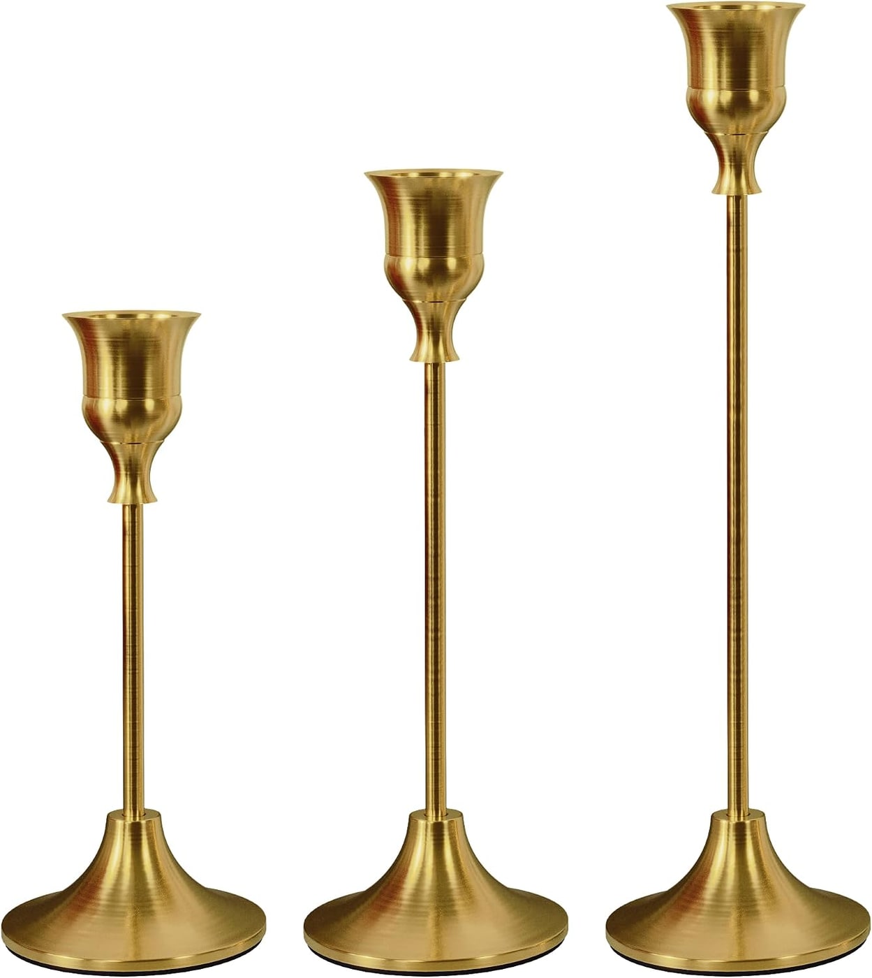 Three graduated metal candlestick holders with a polished finish on a neutral Thanksgiving table.