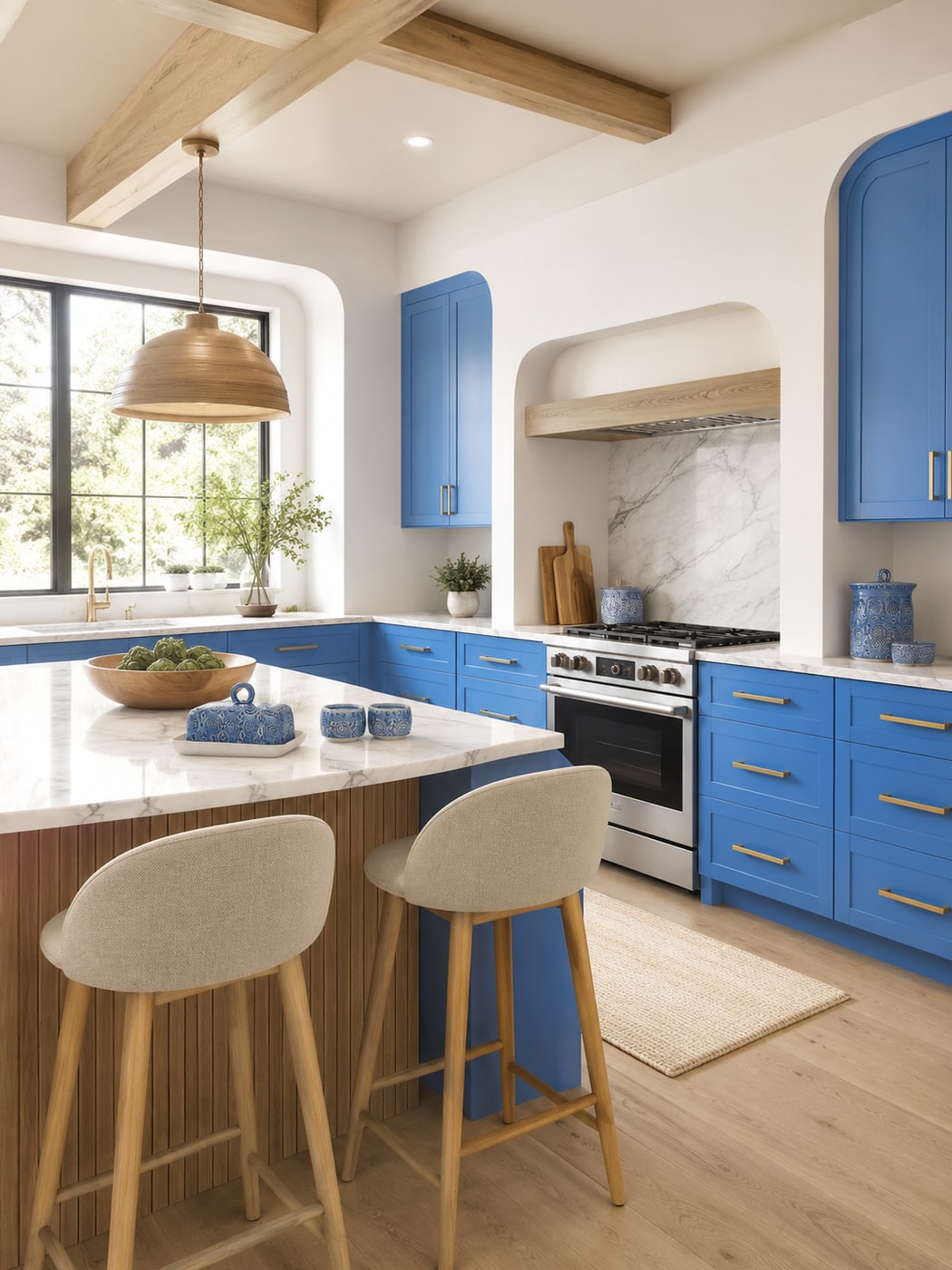 Modern kitchen with bright blue cabinets, natural wood finishes, curved beige stools, and artisan blue stoneware on marble-look counters.